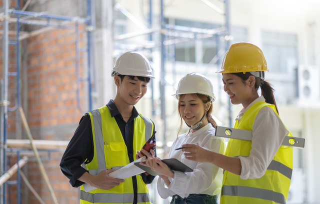 Professional Construction and Engineer team Working on workplace. Professional black architect and construction worker working look at blueprint plan on site.